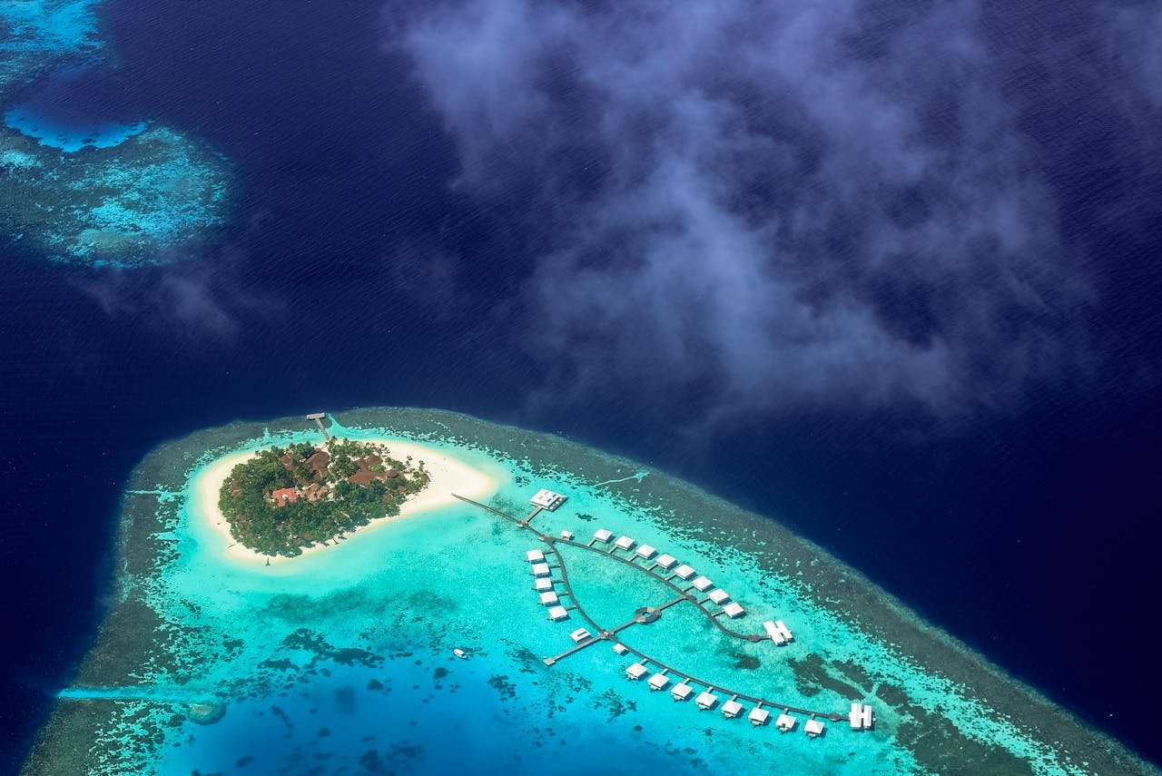 about-us Stunning aerial shot of a tropical island resort surrounded by turquoise waters in the Maldives.